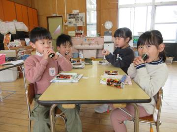 室内で巻き寿司を食べる園児たちの様子